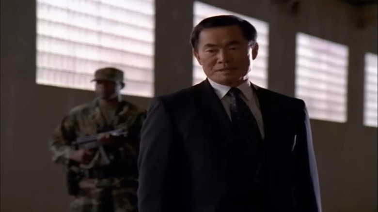 George Takei in a warehouse wearing a black suit in Diagnosis: Murder (1993)