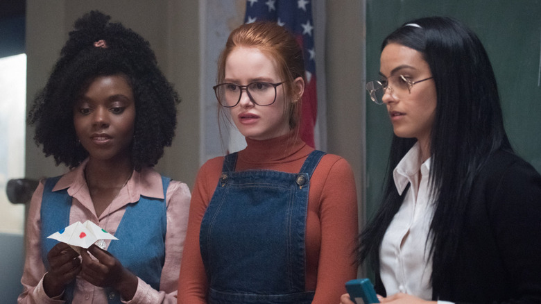 Sierra McCoy rolünde Ashleigh Murray, Penelope Blossom rolünde Madelaine Petsch ve Hermione Gomez rolünde Camila Mendes, hepsi 80'lerden ilham alan kıyafetler giyiyor ve inanamadıkları bir şeyi izliyorlar. 
