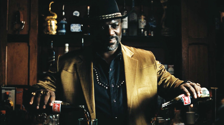 Alamo Brown iki Coca-Cola doldururken sırıtıyor