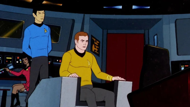 James T. Kirk sitting in the captain's chair with Spock and Uhura behind him on Star Trek: The Animated Series