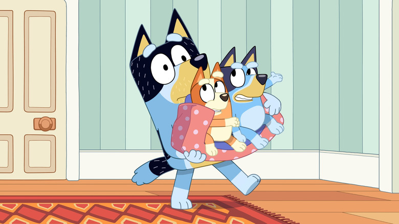 Bandit carrying Bluey and Bingo on Bluey