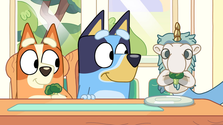 Bluey and Bingo eating broccoli with a puppet on Bluey
