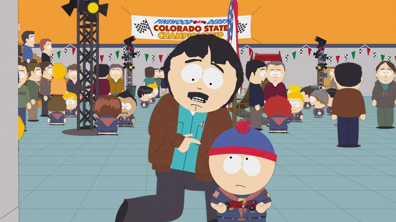 Randy kneels next to Stan at the PInewood Derby on South Park