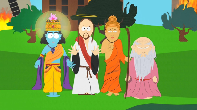 Deities stand side by side in a field with burning buildings on South Park