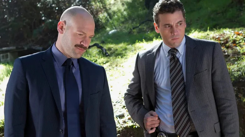 TJ Jaruszalski (Corey Stoll) and Rex Winters (Skeet Ulrich) look down at an outdoor crime scene in Law & Order: LA