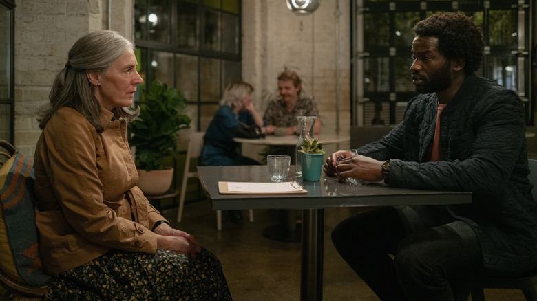 Standish (Saskia Reeves) talking to Sean Donovan (Sope Dirisu) at a table in Slow Horses Season 3