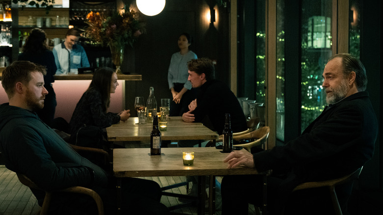 Jack Lowden as River Cartwright talking to Hugo Weaving as Frank Harkness at a table in Slow Horses