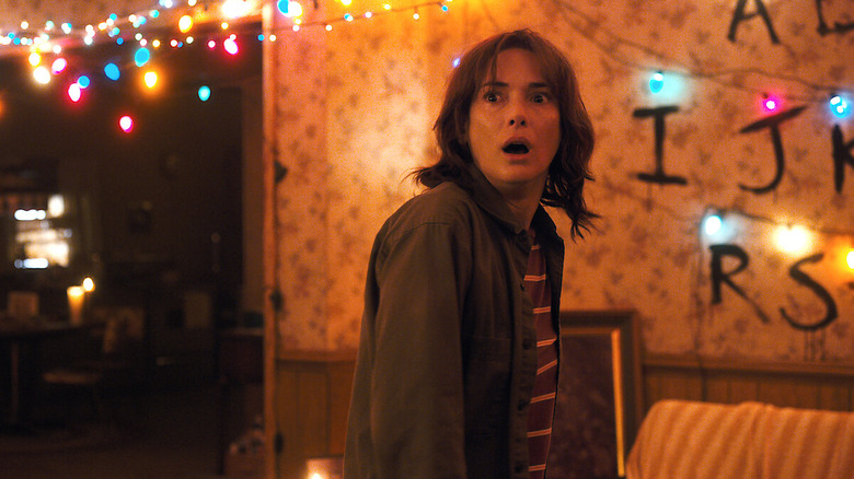 Joyce Byers stands in front of her Christmas lights set-up in "Stranger Things" (2016)