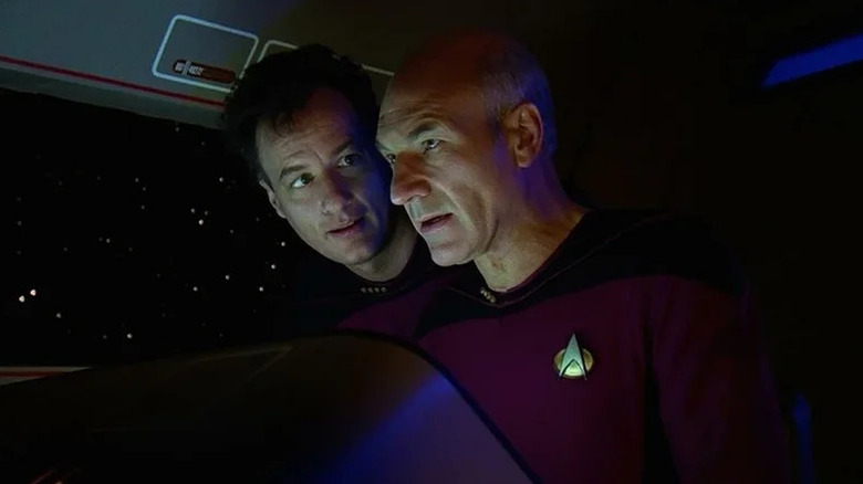 Q (John de Lancie) looks over the shoulder of Jean-Luc Picard (Patrick Stewart) in a shuttlecraft in Star Trek: The Next Generation