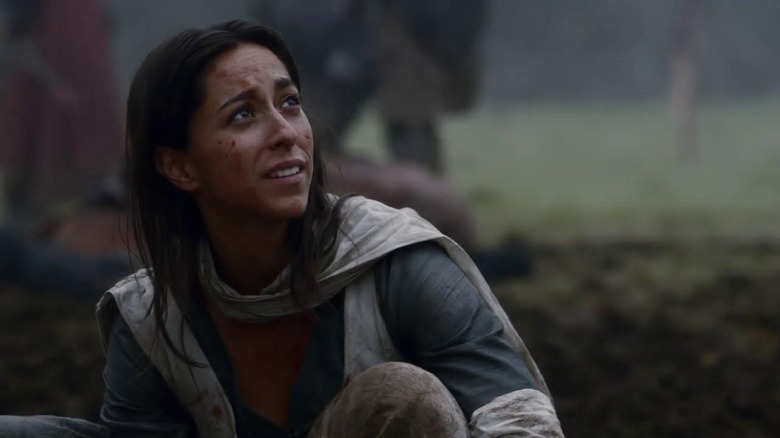 Oona Chaplin as Talisa crouching on a battlefield in Game of Thrones