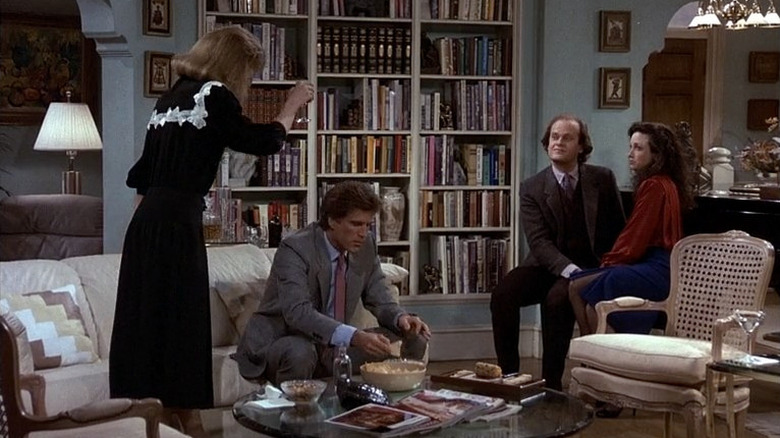 Shelly Long, Ted Danson, Kelsey Grammer, and Bebe Neuwirth as Diane Chambers, Sam Malone, Dr. Frasier Crane, and Dr. Lilith Sternin in a living room on Cheers