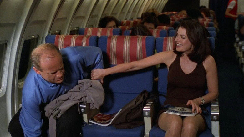 Kelsey Grammer and Sela Ward as Dr. Frasier Crane and Kelly Easterbrook in the passenger section of an airplane