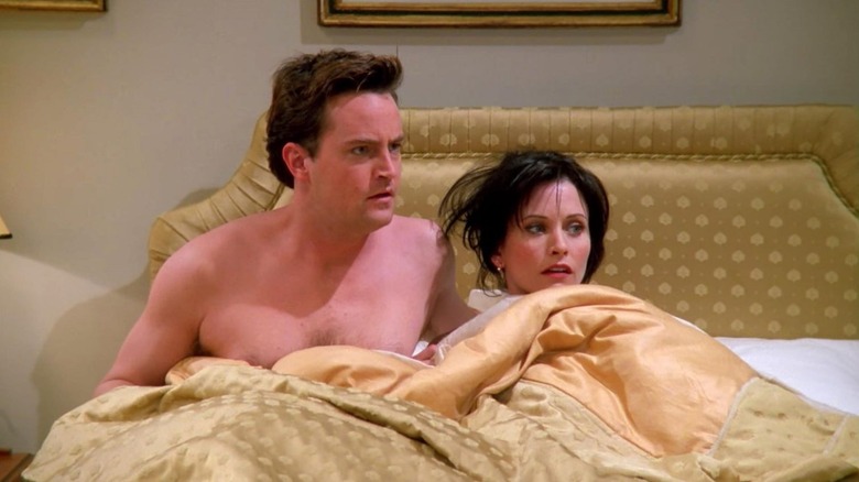Chandler and Monica in bed together looking shocked
