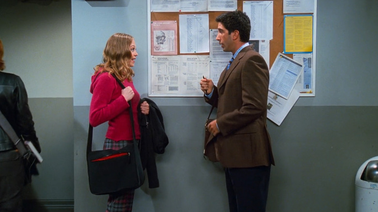 Ross and Elizabeth stand next to bulletin board