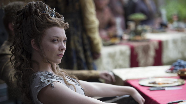 Natalie Dormer as Margaery sitting at a table outdoors in Game of Thrones