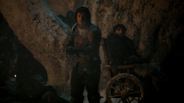 Theon standing in front of Bran and brandishing a spear on Game of Thrones S8E3