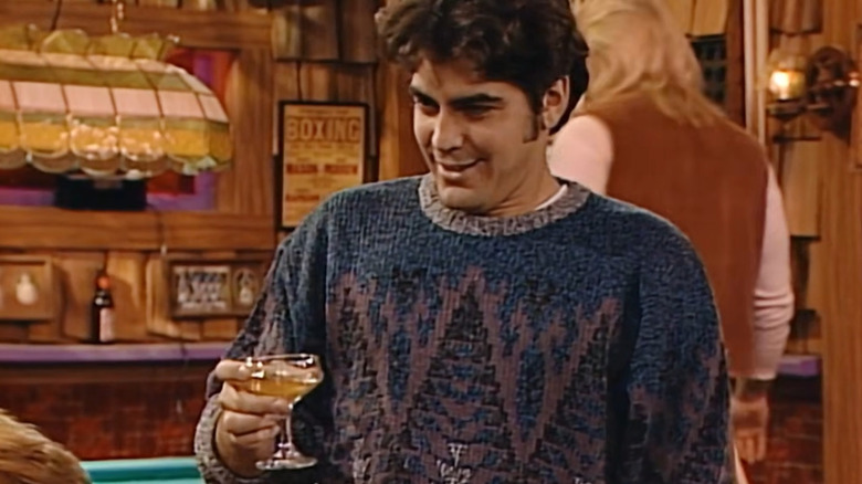 George Clooney as Booker Brooks holding drink in bar on "Roseanne"