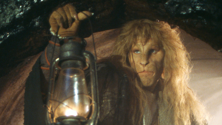 Vincent lifting a lantern in a dark tunnel in Beauty and the Beast (1987)