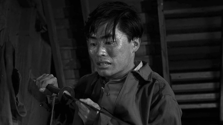 Arthur Takamori looking down at a Samurai sword in his hands in The Twilight Zone