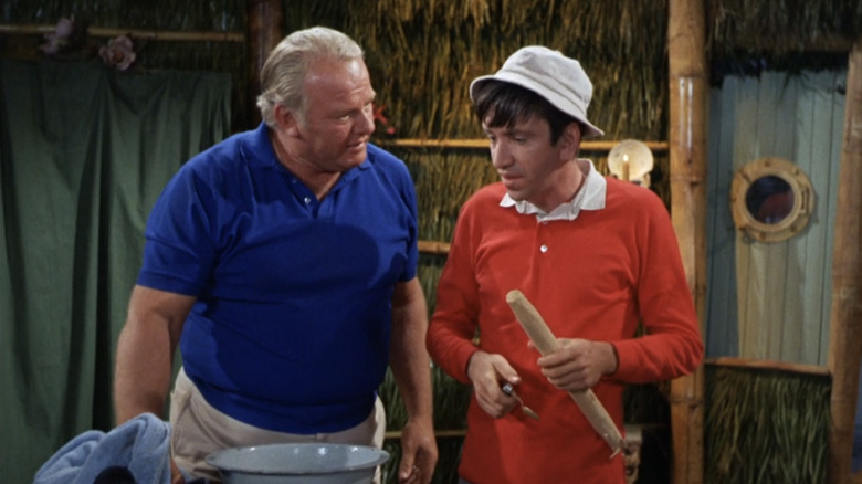 Alan Hale Jr.'s Skipper stands beside Bob Denver's Gilligan in a shack on Gilligan's Island