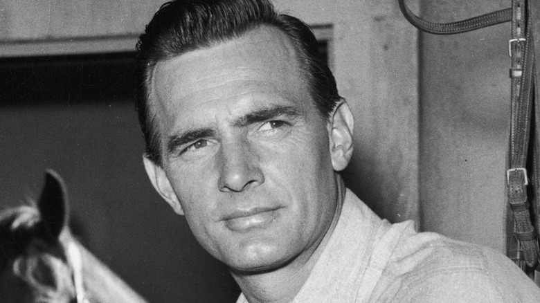 Dennis Weaver posing in a barn