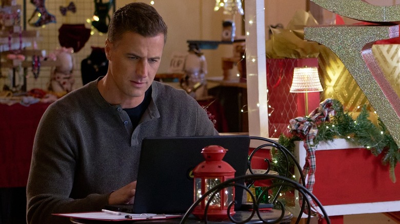 Taylor seated at a cafe table working on his laptop