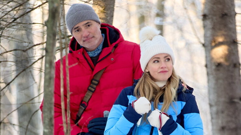 Ridge and Lexi wearing winter jackets and hats during a stroll in the woods
