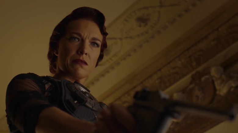 Magdalena points a pistol at someone on the floor in "12 Monkeys" (2015)
