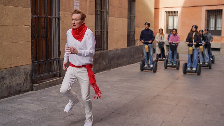 Host Conan O'Brien runs from people on Segway scooters in Spain