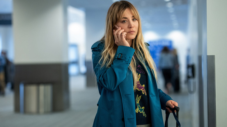 Kaley Cuoco talking on a phone at the airport in a scene from "The Flight Attendant"
