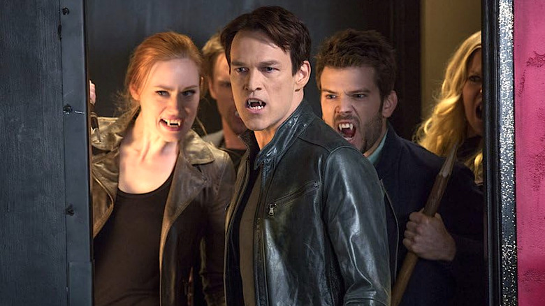 Bill, Jessica ve diğer vampirler bir arada durup True Blood'da sivri dişlerini gösteriyorlar