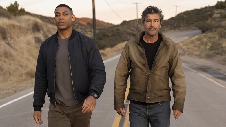 Aaron Pierre as John Stewart and Kyle Chandler as Hal Jordan walking down road in "Lanterns"