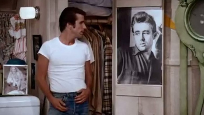 Fonzie looking at James Dean poster in apartment