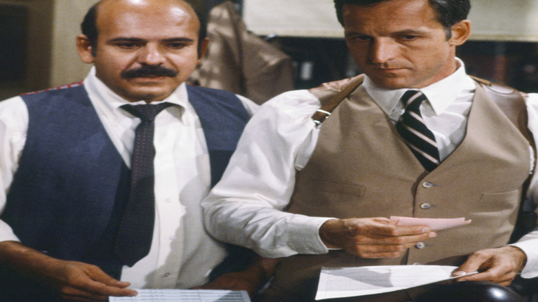 Lt. Calletano stands next to Captain Furillo as they look ahead with concern