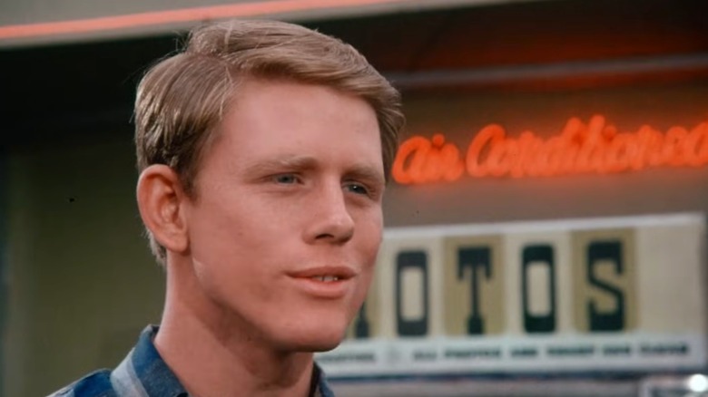 Richard Cunnigham grinning in "Happy Days" in front of a neon sign.