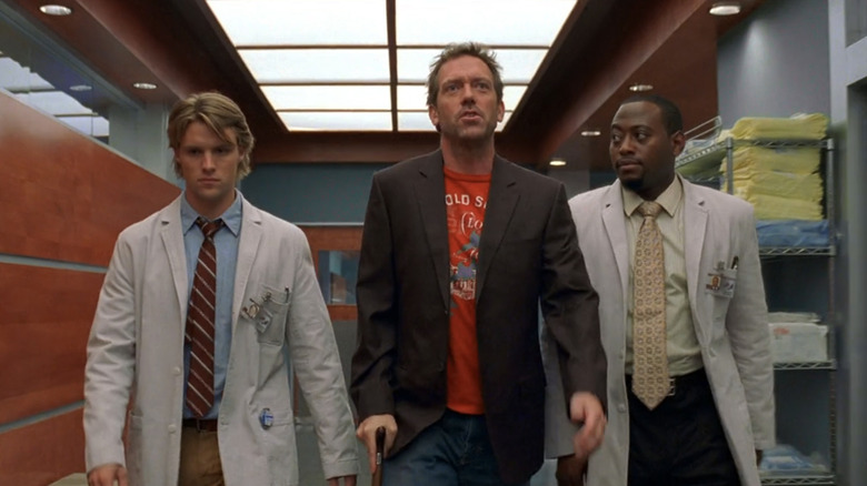Robert Chase, Gregory House e Dr. Eric Foreman caminhando pelo corredor do hospital de House (2004–2012)