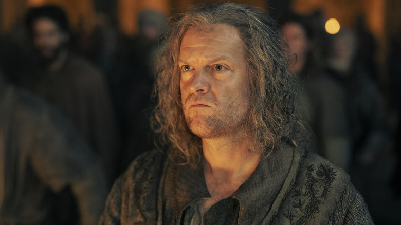 Tom Bennett as Ulf White with his hair down and looking serious with light on his face in House of the Dragon