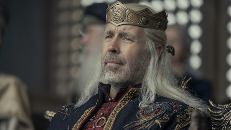 Paddy Considine as Viserys I Targaryen sitting and wearing his crown in House of the Dragon