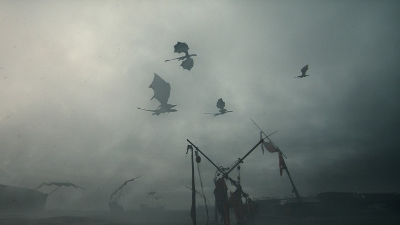 Four dragons soaring over a fleet of wrecked ships covered in fog in House of the Dragon Season 3 (2026)