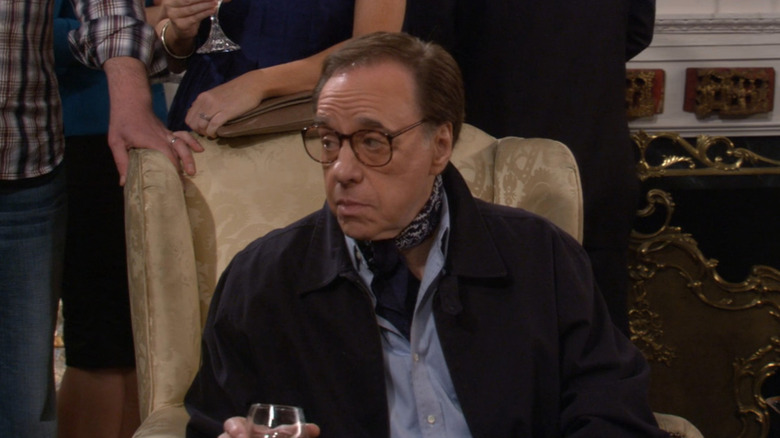 Peter Bogdanovich sitting in armchair at a party in How I Met Your Mother