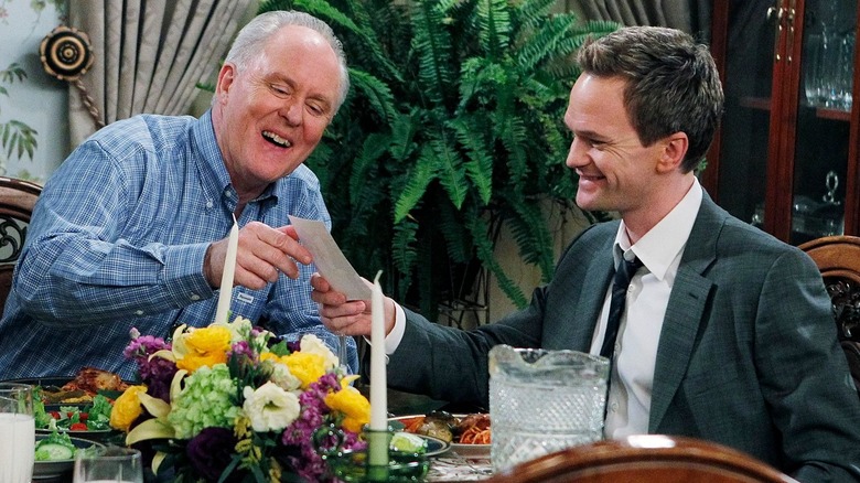 Jerry (John Lithgow) and Barney (Neil Patrick Harris) sitting at a table together in "How I Met Your Mother"