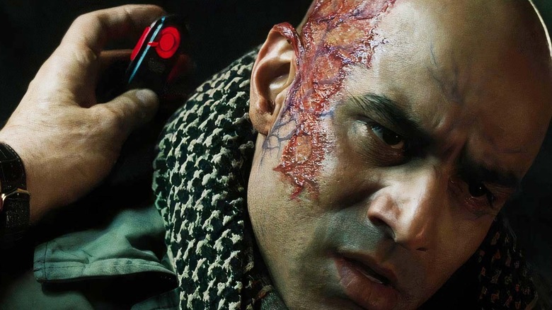 A heavily scarred Raza Hamidmi al-Wazar is subjected to paralyzing soundwaves by Obadiah Stane in Marvel's Iron Man.