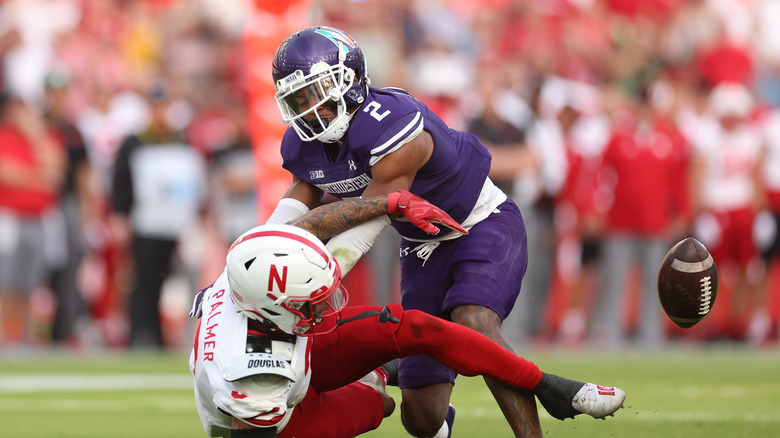 Trey Palmer of Nebraska Cornhuskers is tackled by Cameron Mitchell of Northwestern Wildcats