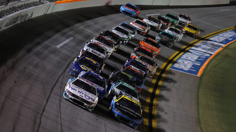 A line of cars racing in a pack at the 2025 Coke Zero Sugar 400