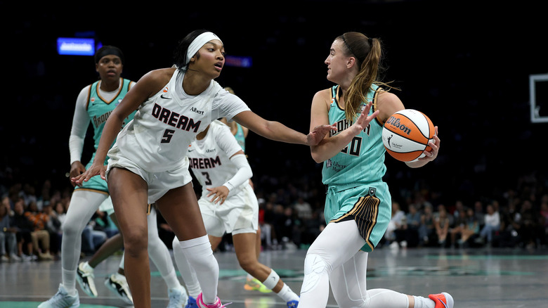 Angel Reese guarding Sabrina Ionescu on a drive