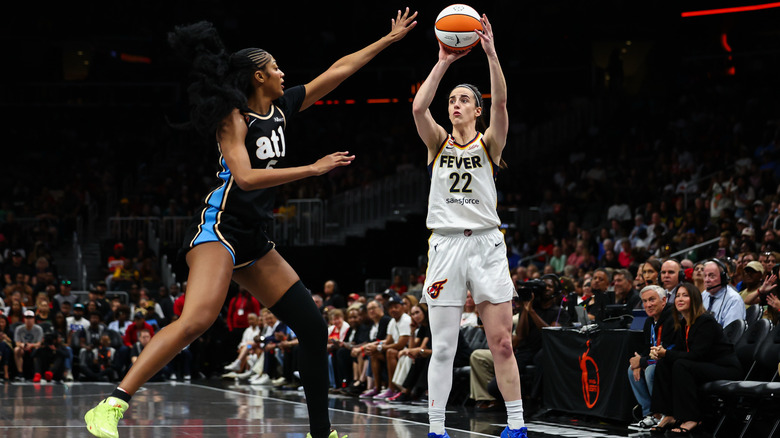 Caitlin Clark puts up a shot over Angel Reese