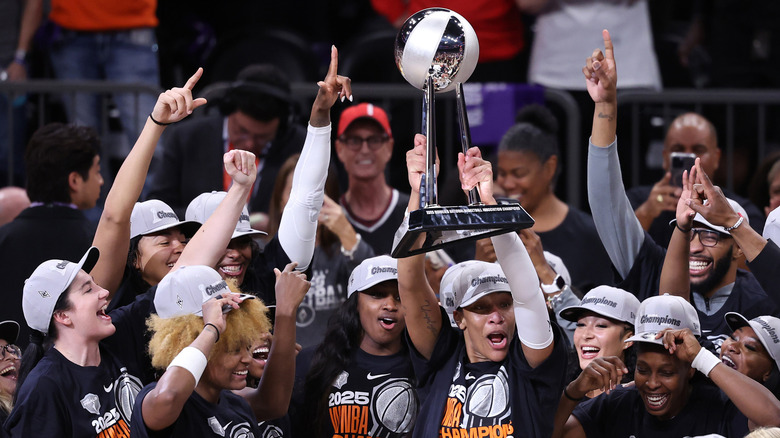 The Las Vegas Aces holding the WNBA trophy after winning the 2025 Finals