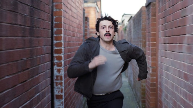 Brendan (Anthony Boyle) running down an alleyway scared on Say Nothing