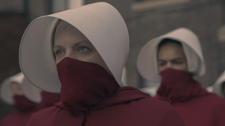 June (Elisabeth Moss) in her Handmaid outfit with a mask over her face on The Handmaid's Tale