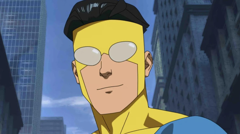 Invincible (Steven Yeun) stands smugly in a city during Invincible.